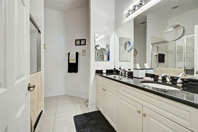 bathroom featuring vanity, a shower with shower door, and tile patterned flooring