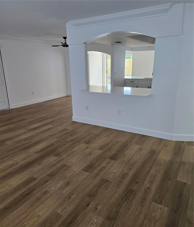 spare room featuring dark wood-type flooring, ceiling fan, and ornamental molding