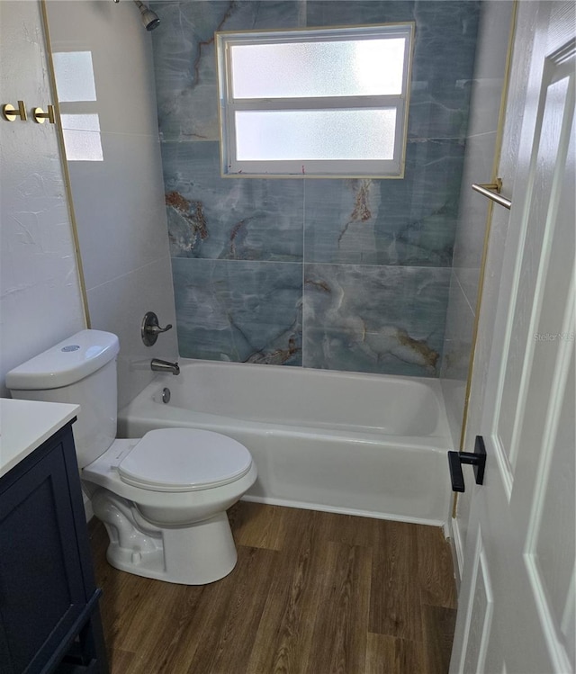 full bathroom with vanity, hardwood / wood-style floors, tiled shower / bath combo, and toilet