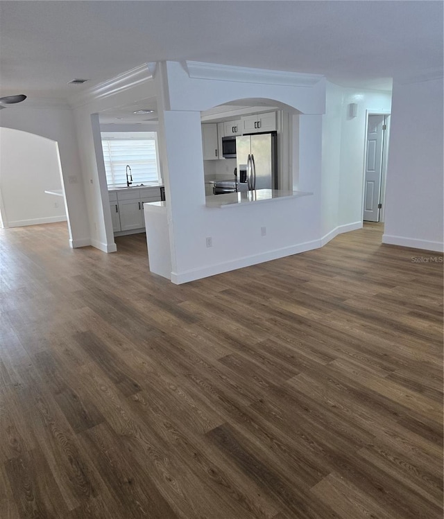 unfurnished living room featuring sink and dark hardwood / wood-style floors