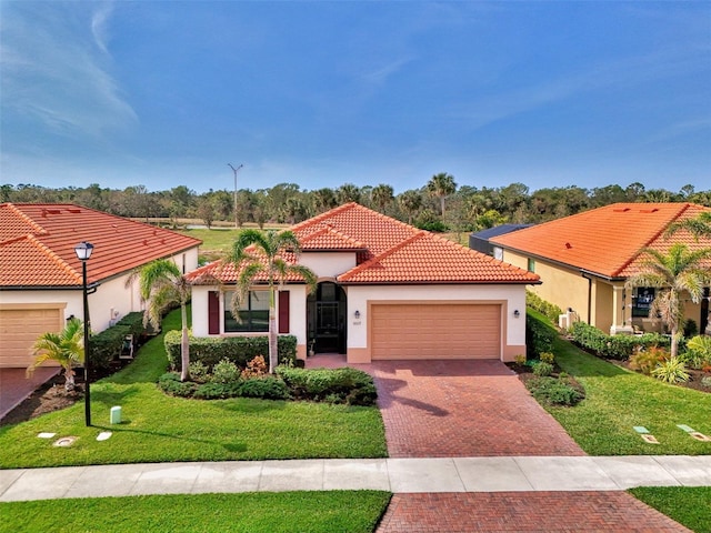 mediterranean / spanish home featuring a garage and a front lawn