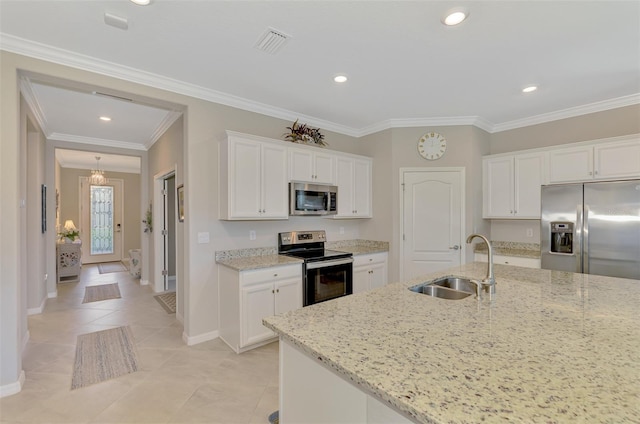 kitchen with light stone counters, appliances with stainless steel finishes, sink, and white cabinets