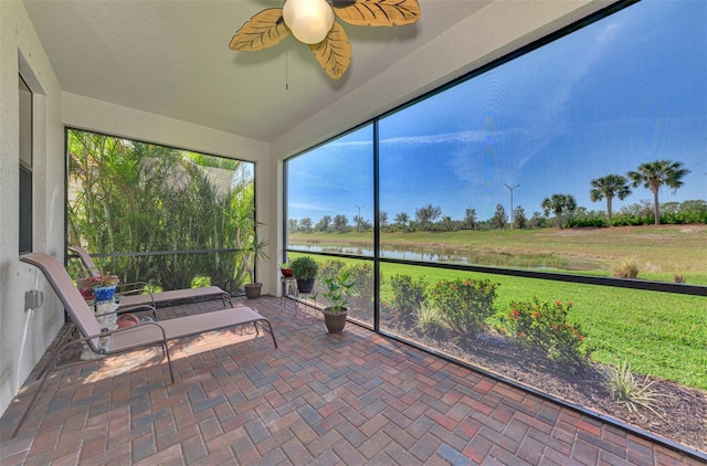 unfurnished sunroom with a water view and ceiling fan