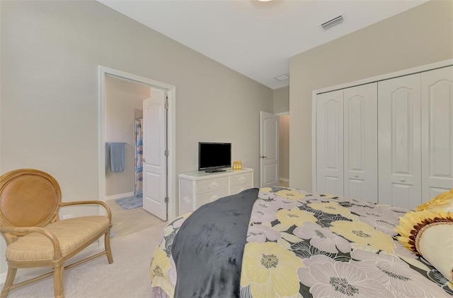 carpeted bedroom featuring ensuite bathroom and a closet