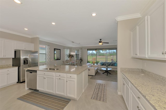 kitchen featuring sink, appliances with stainless steel finishes, an island with sink, light stone countertops, and white cabinets