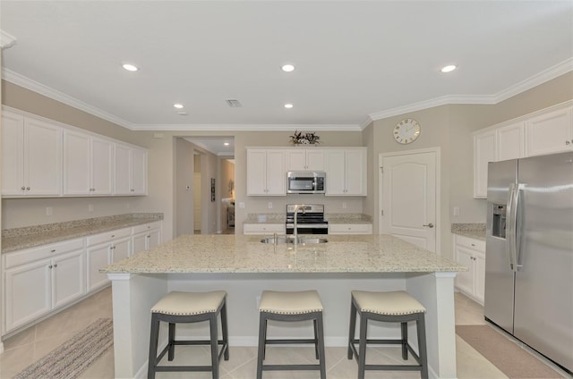 kitchen with appliances with stainless steel finishes, sink, a kitchen island with sink, and white cabinets