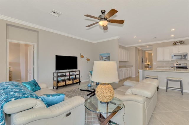 tiled living room with ceiling fan and ornamental molding