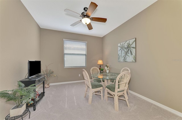 dining room with ceiling fan and light colored carpet