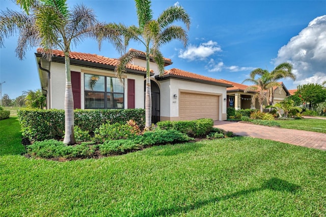 mediterranean / spanish-style house featuring a garage and a front yard