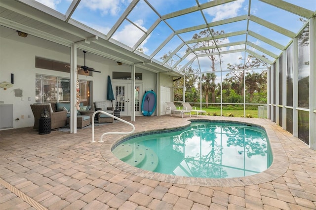 outdoor pool with a lanai, a patio area, and a ceiling fan