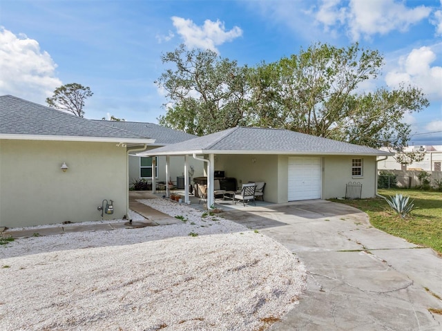 view of front of property featuring a garage, roof with shingles, and stucco siding