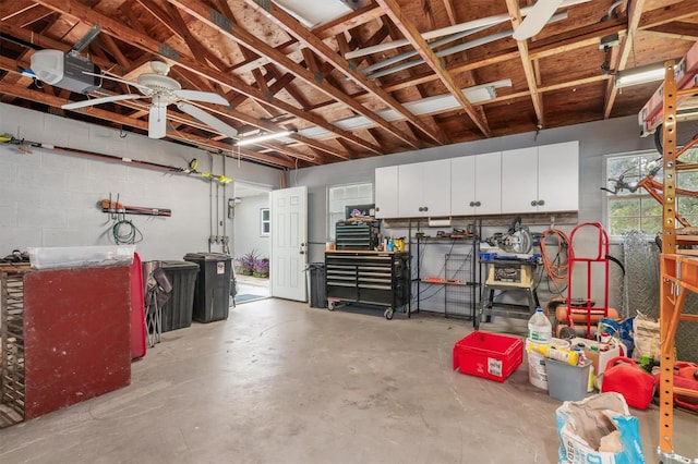 garage featuring concrete block wall and a garage door opener