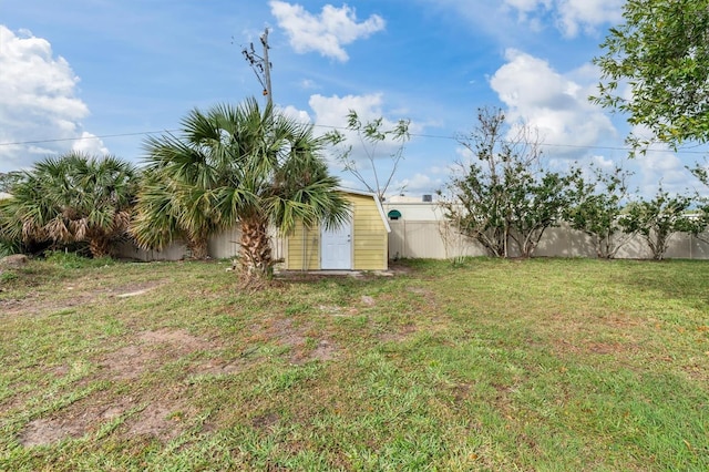 view of yard featuring an outbuilding, a shed, and a fenced backyard