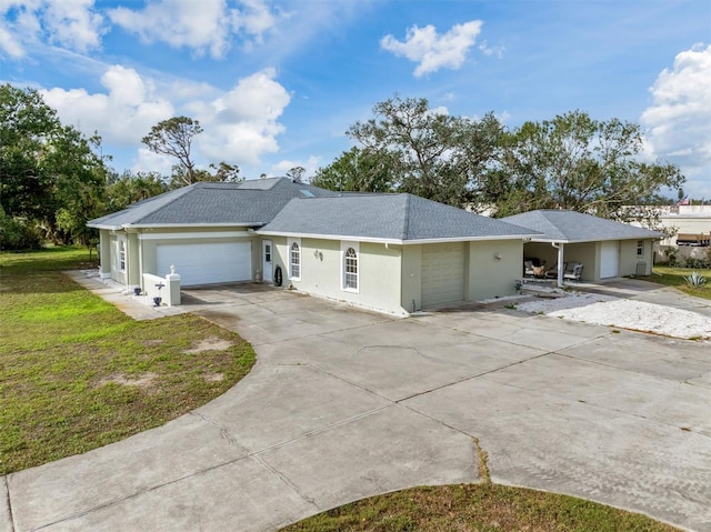 single story home featuring concrete driveway, roof with shingles, an attached garage, a front yard, and stucco siding