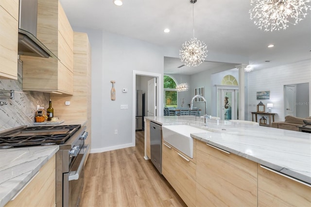 kitchen featuring appliances with stainless steel finishes, a chandelier, a sink, and light brown cabinetry