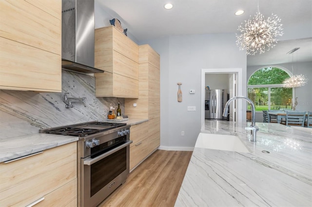 kitchen featuring appliances with stainless steel finishes, decorative light fixtures, an inviting chandelier, and light brown cabinetry