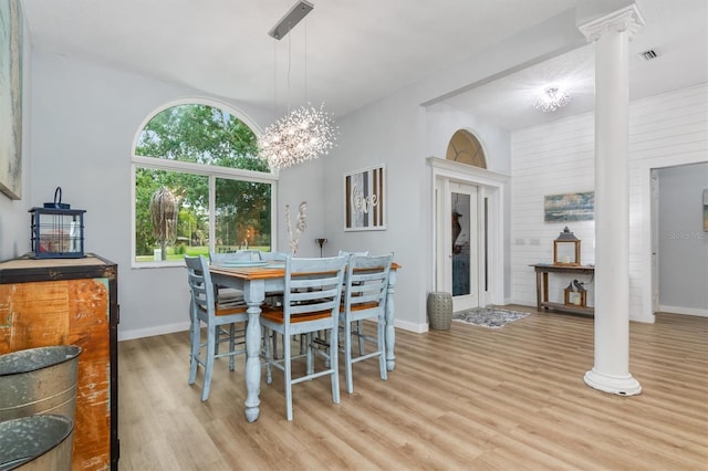 dining space with light wood-style floors, baseboards, visible vents, and ornate columns