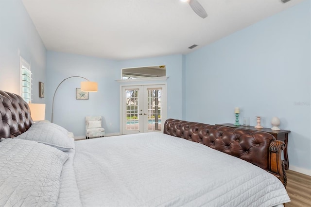 bedroom featuring french doors, multiple windows, wood finished floors, and visible vents