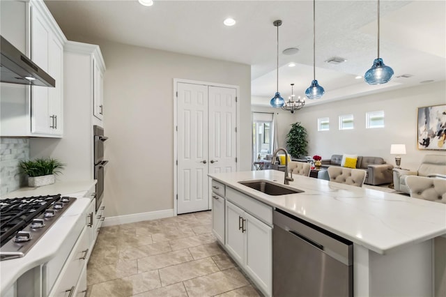 kitchen featuring sink, stainless steel appliances, white cabinets, decorative light fixtures, and wall chimney exhaust hood