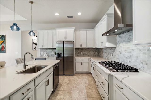 kitchen with wall chimney exhaust hood, white cabinetry, light stone counters, appliances with stainless steel finishes, and pendant lighting