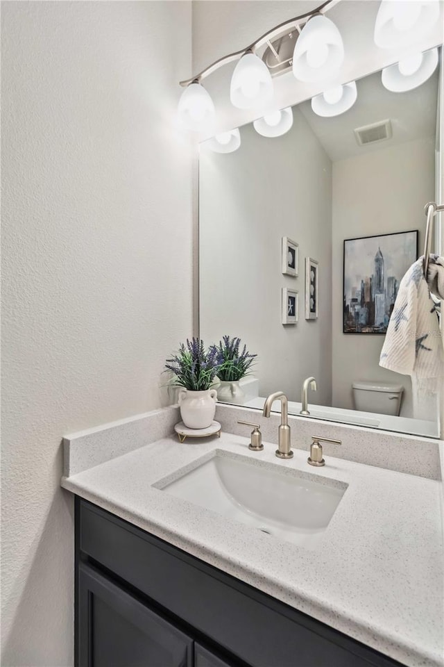 bathroom featuring vanity and toilet