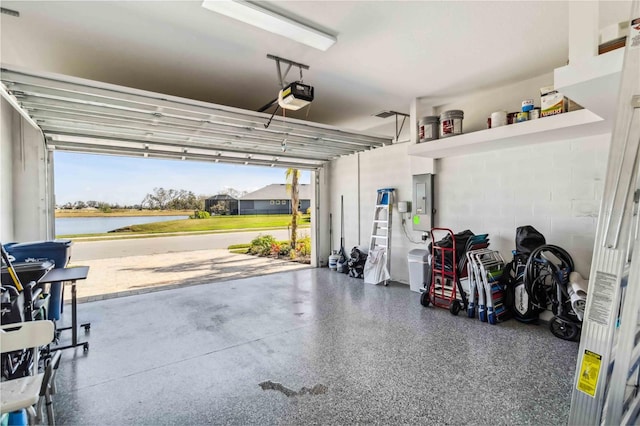 garage with a garage door opener, a water view, and electric panel