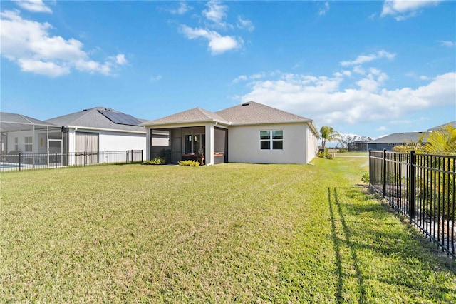 rear view of property with a yard and a sunroom