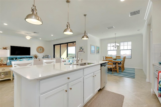 kitchen featuring pendant lighting, dishwasher, an island with sink, sink, and white cabinets