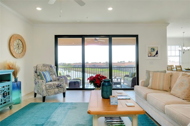 tiled living room with crown molding, ceiling fan with notable chandelier, and a water view