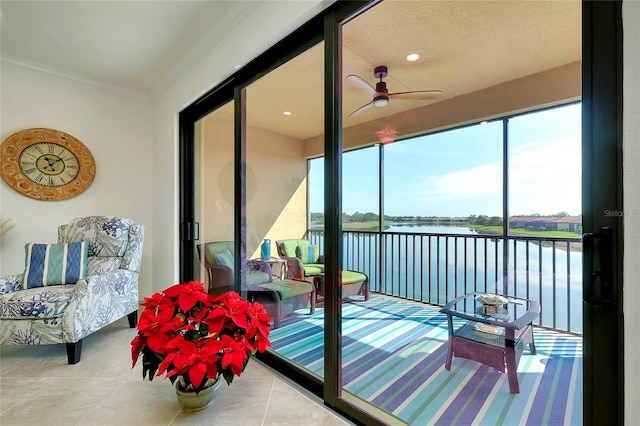 sunroom / solarium featuring ceiling fan and a water view