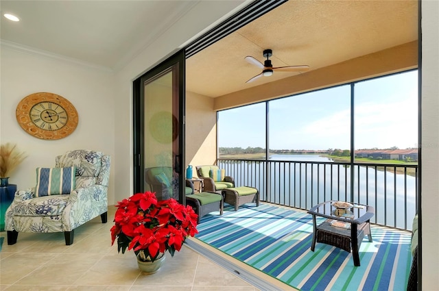 sunroom with a water view and ceiling fan