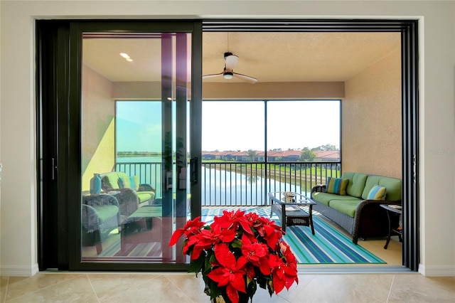 sunroom with a water view and ceiling fan