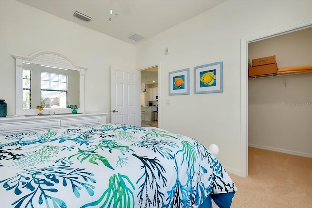 carpeted bedroom with a spacious closet, a closet, visible vents, and baseboards