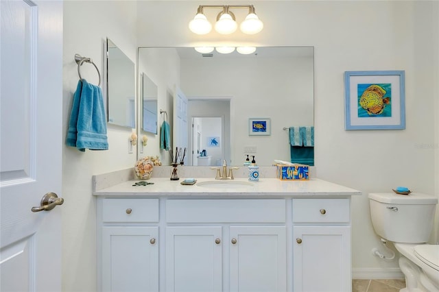 bathroom with toilet, baseboards, and vanity