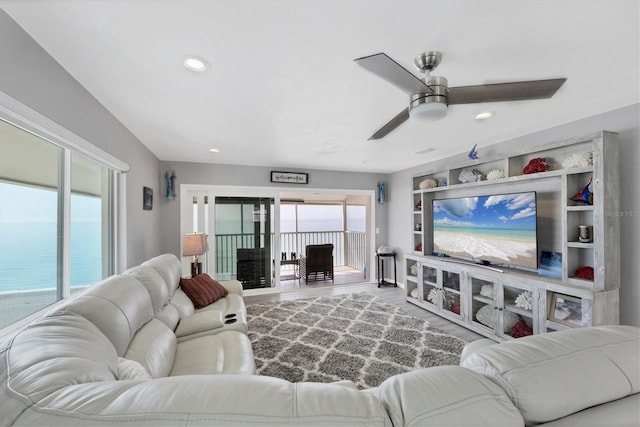 living room with a water view and ceiling fan