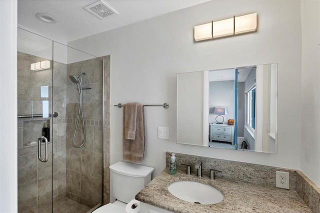 bathroom featuring a shower with door, vanity, and toilet