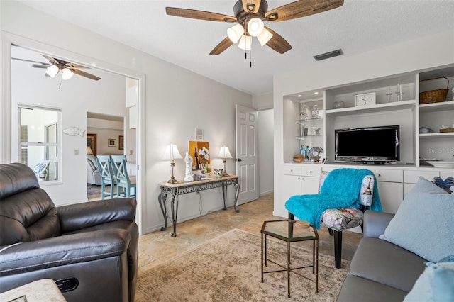 174 Southampton Pl S Unit 345, Venice, FL 34293 - living room featuring a ceiling fan and light stone finish floors