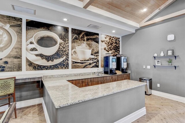 10466 Medjool Dr, Venice, FL 34293 - kitchen with light stone countertops, recessed lighting, vaulted ceiling, and brown cabinetry