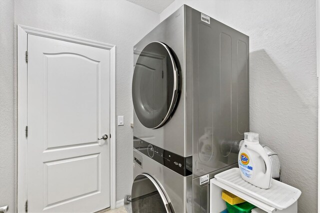 10466 Medjool Dr, Venice, FL 34293 - washroom featuring stacked washer and clothes dryer, a textured wall, and laundry area