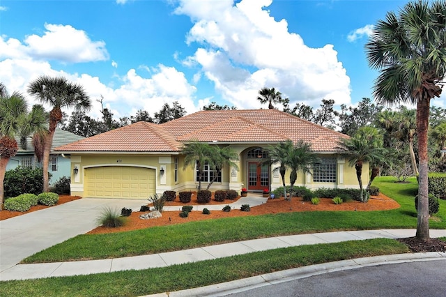 mediterranean / spanish-style house featuring a garage, a tiled roof, concrete driveway, and stucco siding