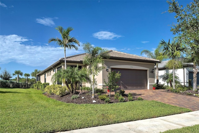 mediterranean / spanish house with a garage and a front lawn