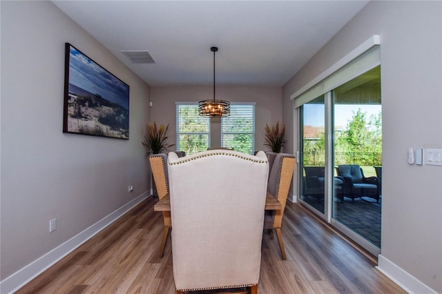 dining space featuring an inviting chandelier and hardwood / wood-style floors