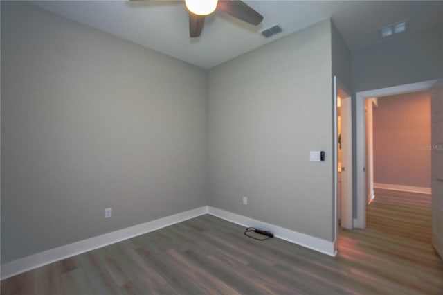 spare room with dark hardwood / wood-style floors and ceiling fan