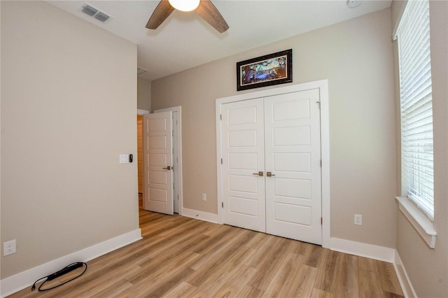 unfurnished bedroom with ceiling fan, a closet, and light hardwood / wood-style flooring