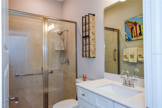 bathroom with vanity, a shower with door, and toilet