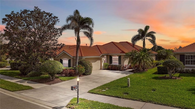 mediterranean / spanish-style house featuring a front lawn, a tiled roof, concrete driveway, stucco siding, and an attached garage