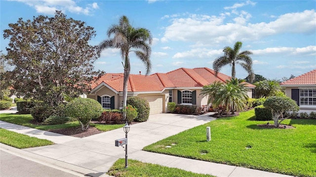 mediterranean / spanish-style home with a garage, concrete driveway, a front lawn, and a tile roof