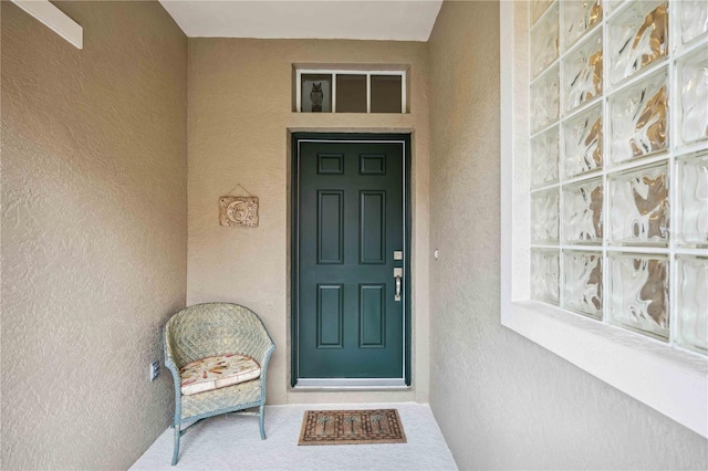 entrance to property featuring stucco siding