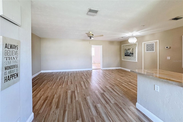 unfurnished living room featuring ceiling fan and light wood-type flooring