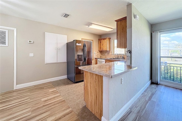 kitchen featuring sink, tasteful backsplash, white cabinetry, appliances with stainless steel finishes, and kitchen peninsula